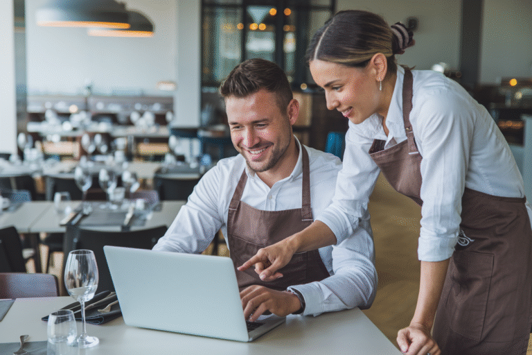 A restaurant owner and staff looking at the laptop