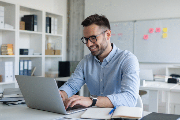 A man working on a laptop in a bright, modern office setting